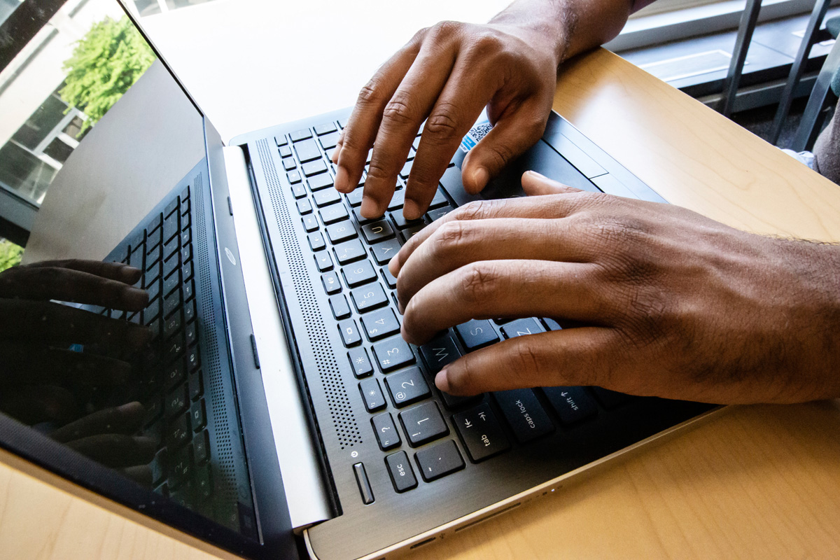 close up of hands typing on a laptop