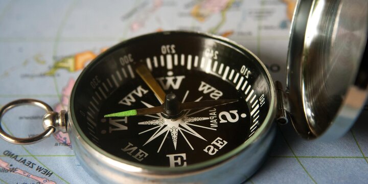 close up of compass sitting on a map