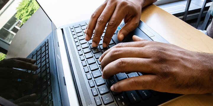 close up of hands typing on a laptop