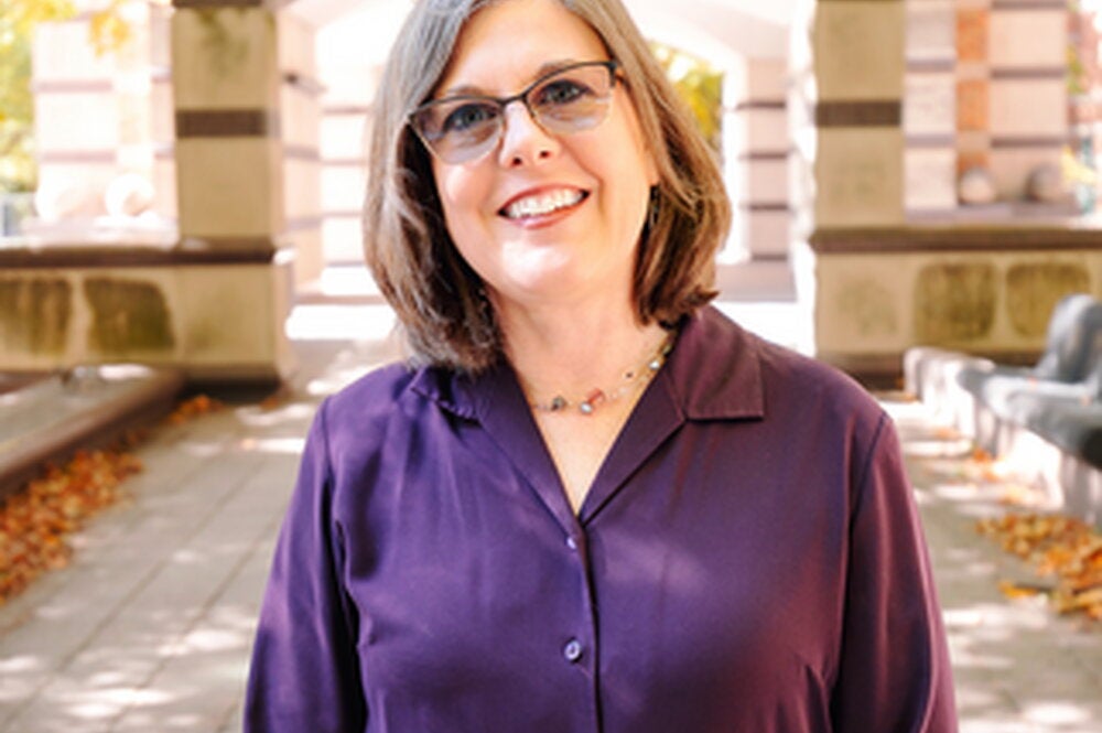 Kara Federmeier standing in the Beckman courtyard in a purple shirt