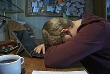 student with head resting on desk