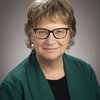 Wendy Heller profile picture wearing dark green sweater and glasses