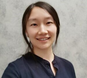 Head shot of Dr. Zhang against a white marble background