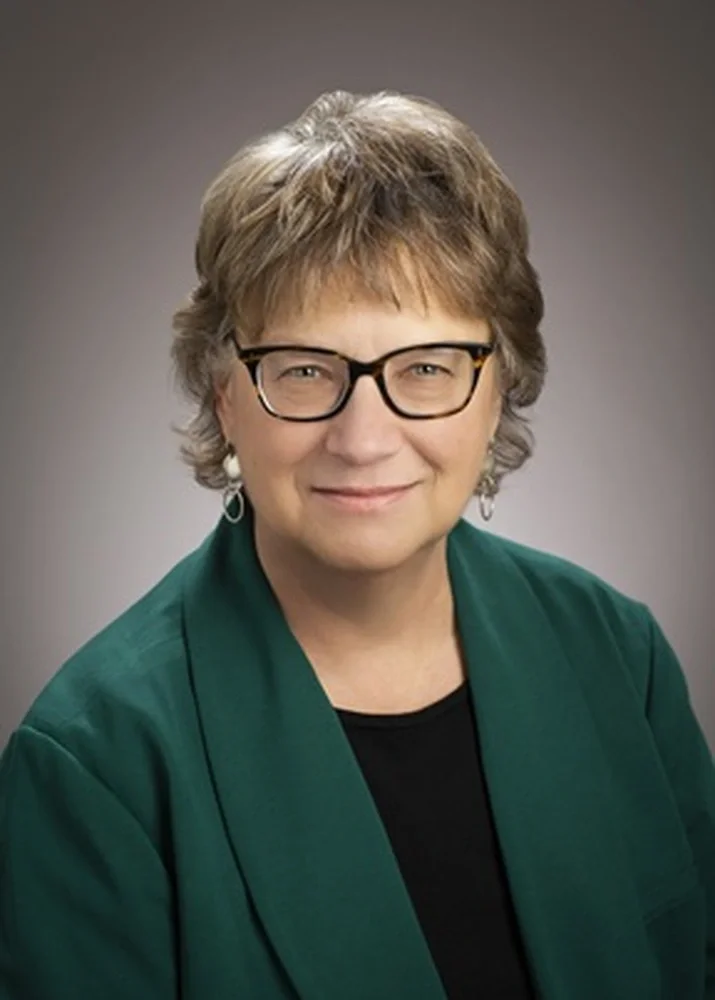 Wendy Heller profile picture wearing dark green sweater and glasses