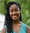 Head shot of Mahogony Monette against greenery background