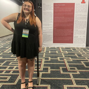 Photograph of Briana Kunstman standing next to a conference poster.