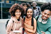A group of Black college students standing in front of a building on a college campus.